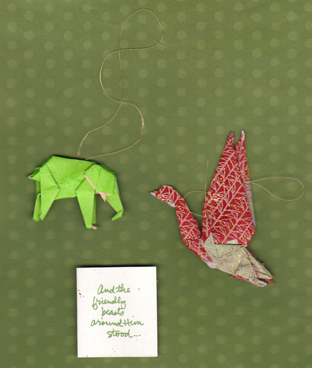 An origami elephant and an origami crane, ornaments with gold thread. "And the friendly beasts around Him stood..."