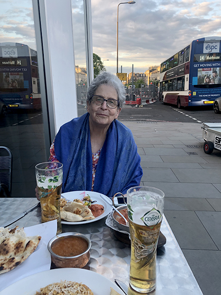 Susan sitting outside, with food and beer