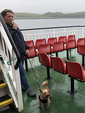 Woman vaping with dog on leash, in rain