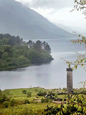 Pillar with sculpture on top by loch