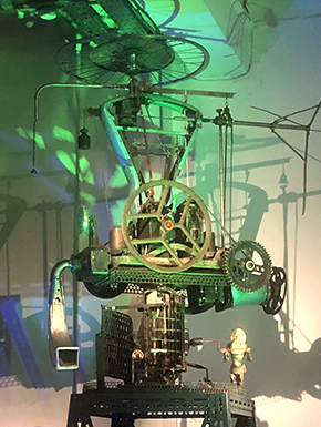 Sculpture with wheels and bells, green light