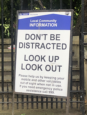 "DON'T BE DISTRACTED: LOOK UP LOOK OUT" sign warning about thieves