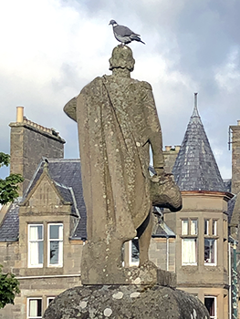 Sculpture of man with bird on his head