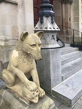 Wolf sculpture with skull by steps to door