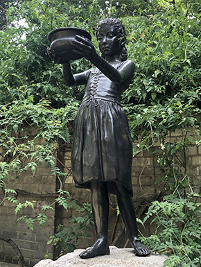 Sculpture of peasant-looking girl holding up dish