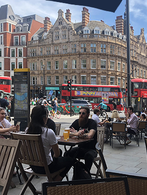 café scene with three red double-decker buses