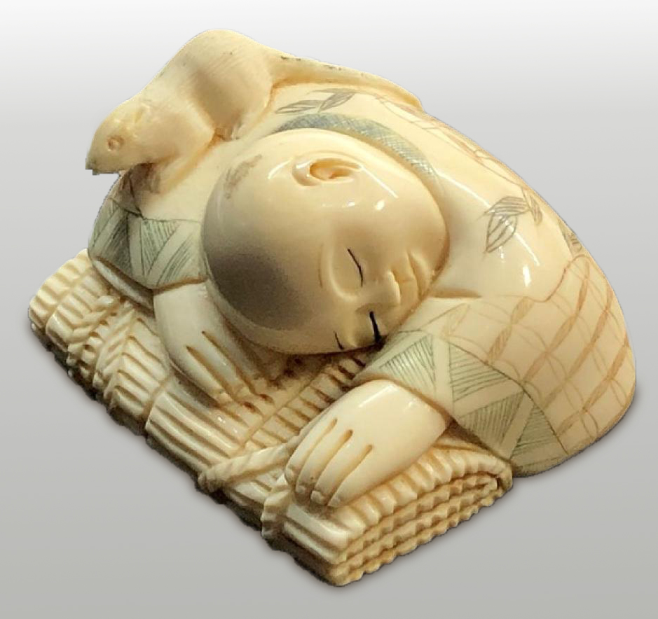 Netsuke of sleeping child with a rat