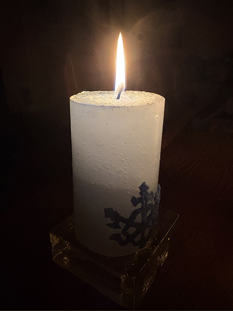 Blue candle lit in the dark